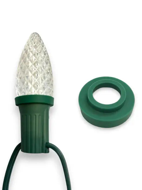 Decorative light bulb with green base and clear cap on a white background