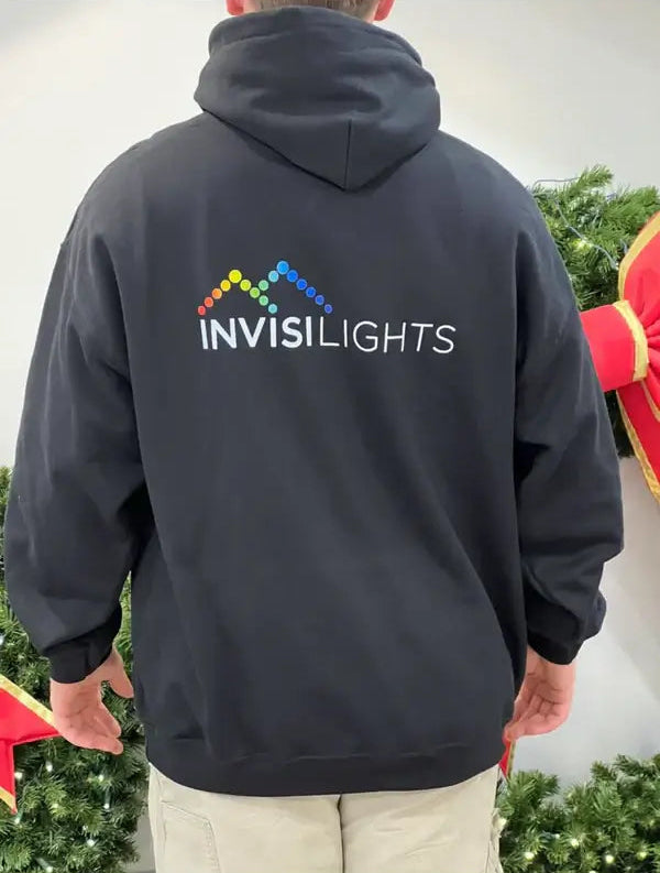 Person wearing a black hoodie with 'INVISILIGHTS' logo on the back, standing outdoors.
