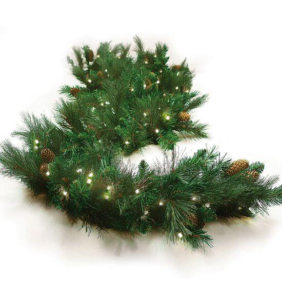 Decorative Christmas garland with lights and pinecones on a white background