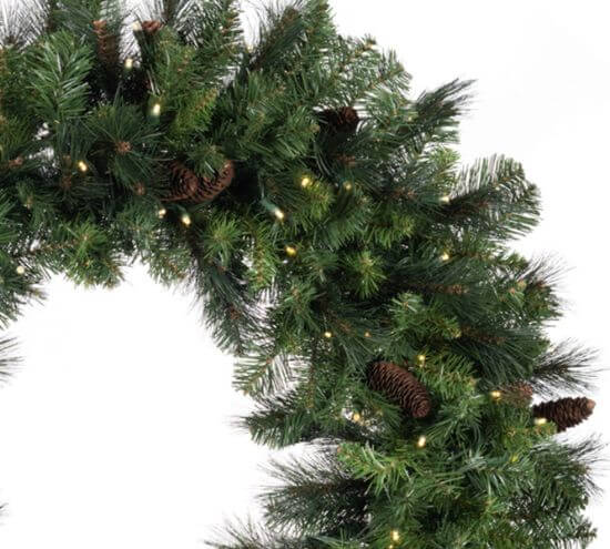 Decorative green garland with pinecones and lights on a white background